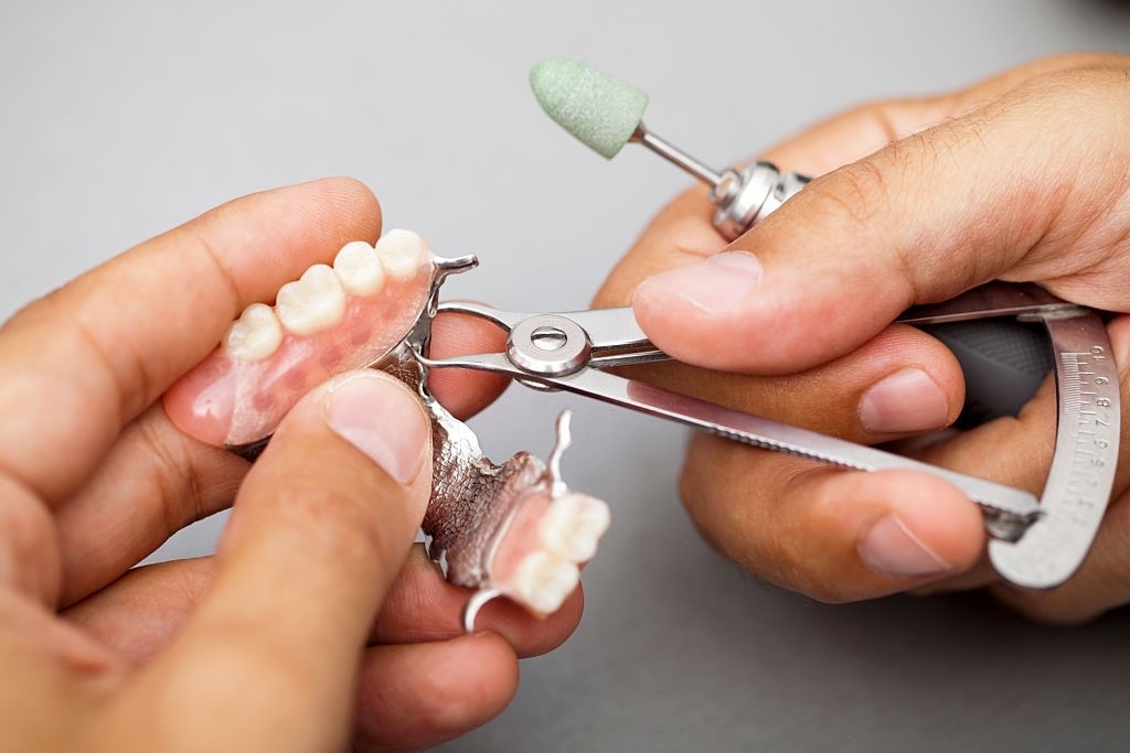 Dental technician measuring dentures
