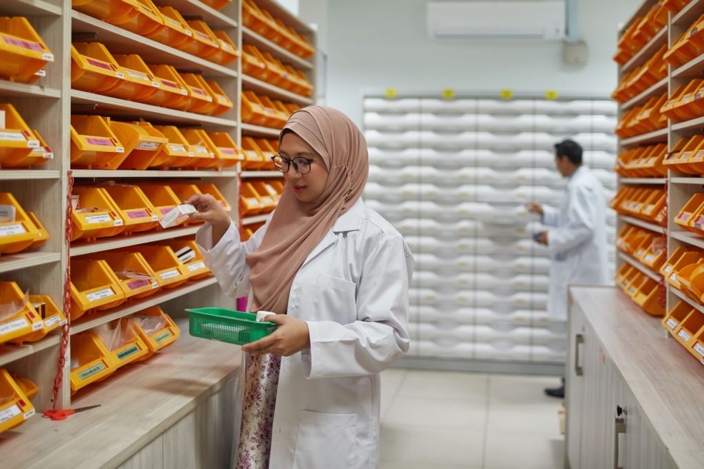 Pharmacist taking prescription medicine from shelf